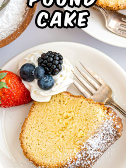 serving of cream cheese pound cake on a white plate with a fork and fresh fruit