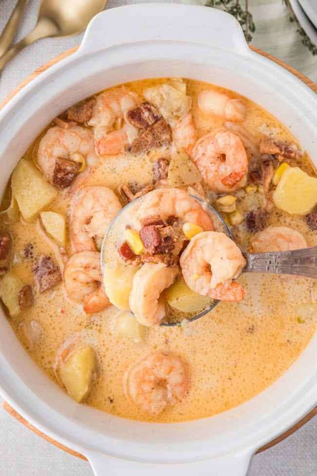 spoonful of shrimp corn chowder over the pot.