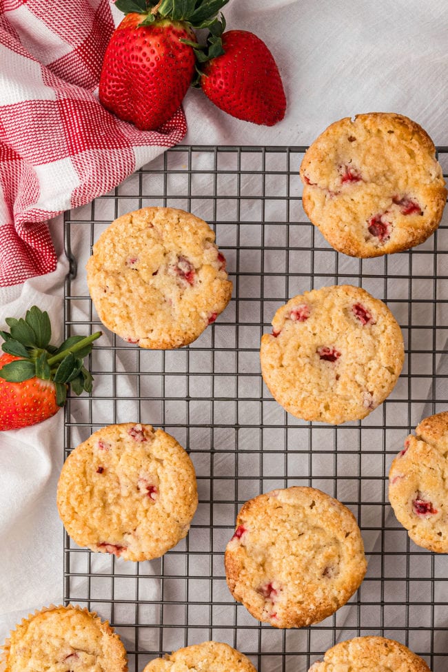 strawberry muffins on a wire cooling rack with a red checked napkin