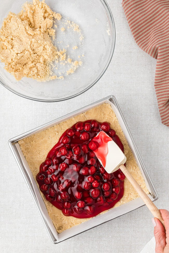 canned cherry pie filling spread over crust in square pan
