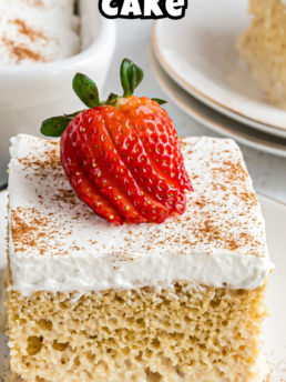 close up of a slice of tres leches cake with a fresh strawberry on top