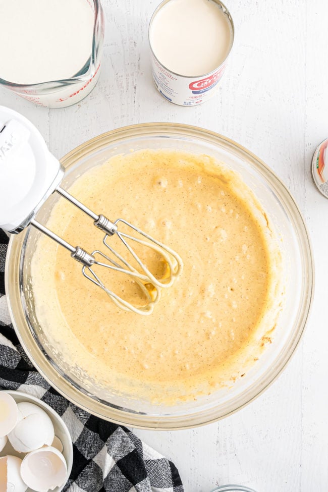 making an easy tres leches cake - Step 1, mixing cake ingredient with an electric hand mixer