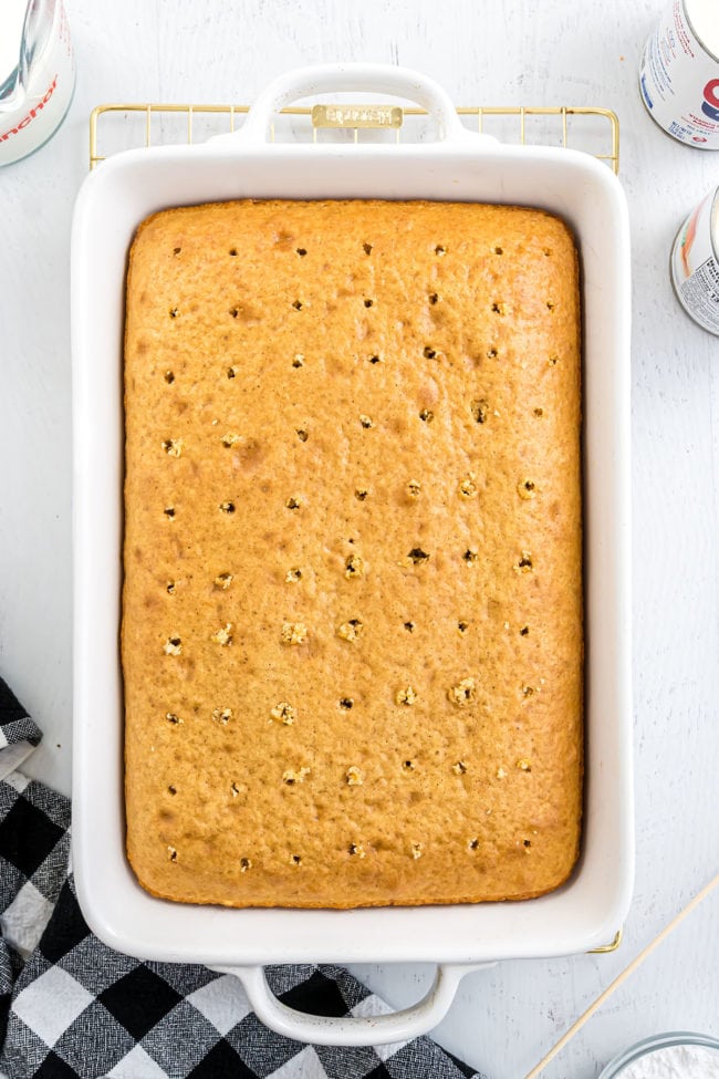 making an easy tres leches cake - poking holes on baked cake