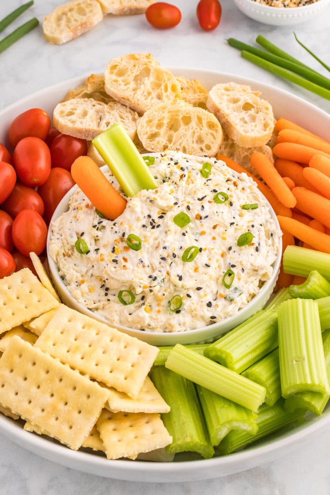 celery and carrots around a bowl of veggie dip