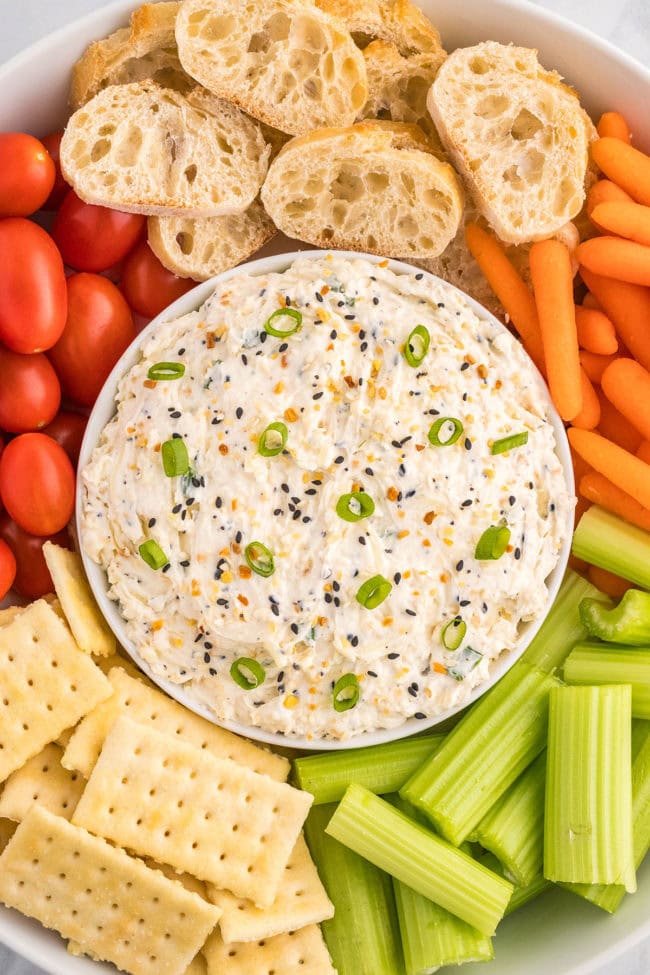 bowl of party dip with veggies and crackers for dipping