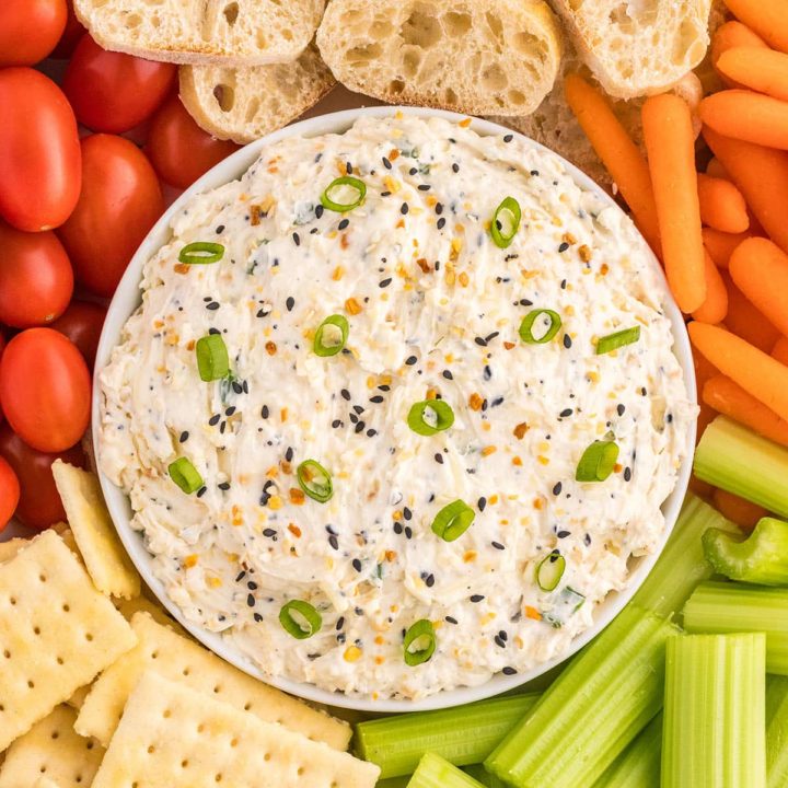 bowl of party dip with veggies and crackers for dipping