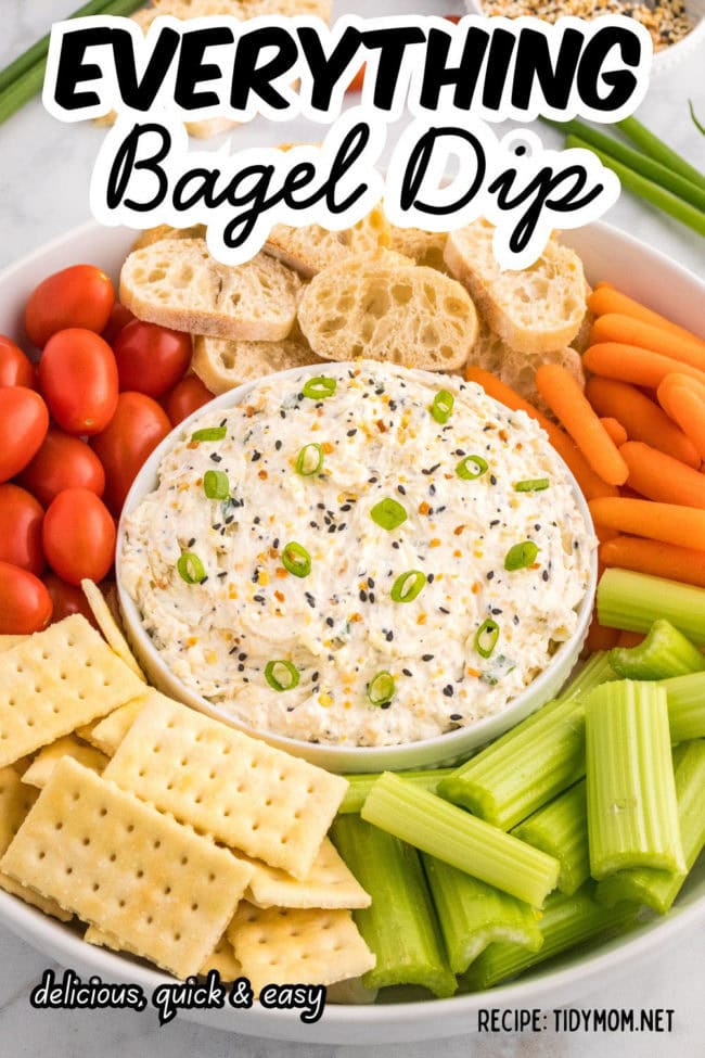 everything bagel dip on a tray with veggies and crackers around