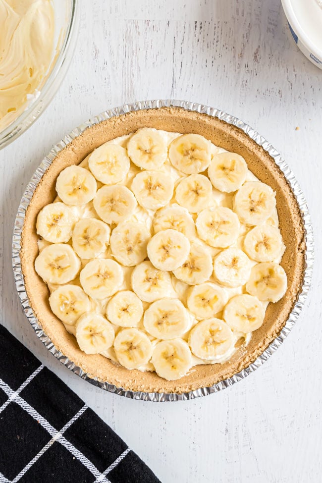 fresh bananas on top of prepared pudding in a pie crust