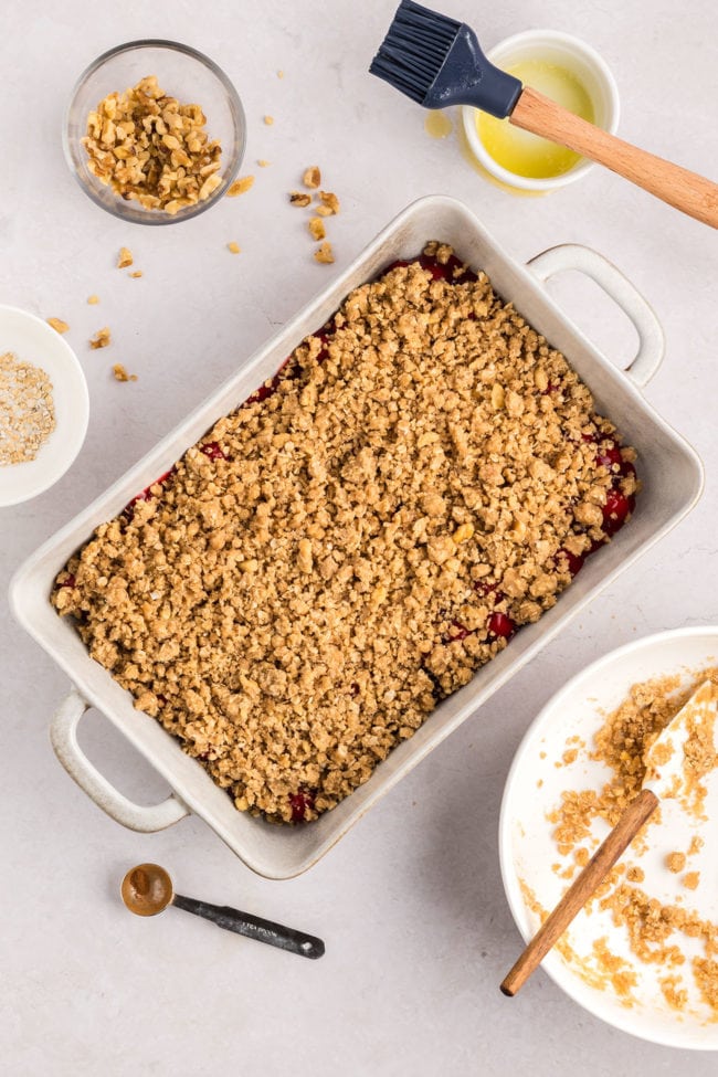 cherry crumble ready for the oven in a white baking dish