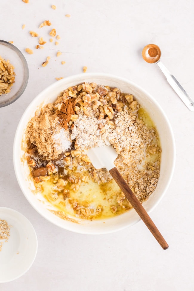 mixing up a crumble topping in a white bowl