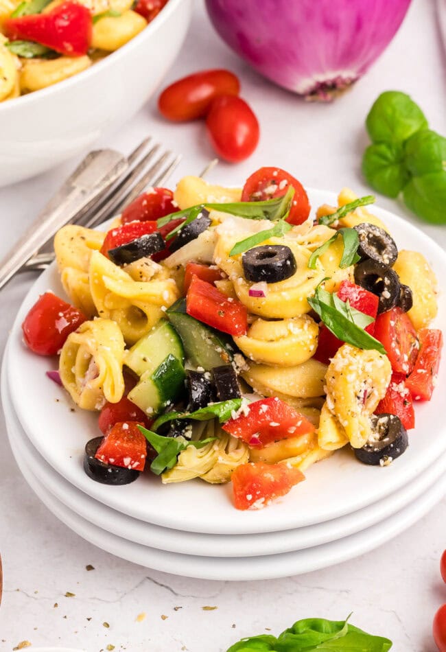 tortellini salad on a stack of white plates