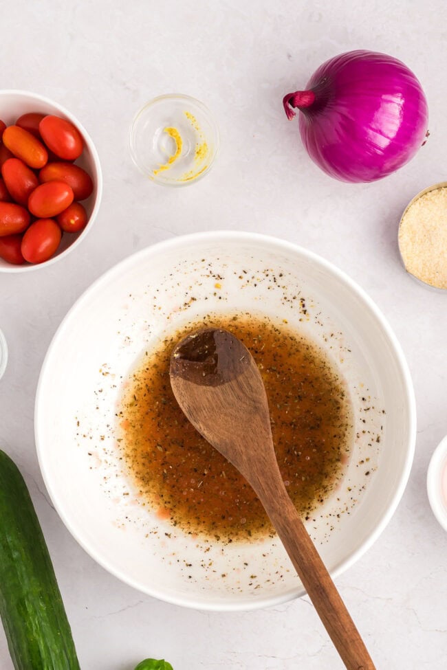 homemade dressing in a white bowl with a wooden spoon