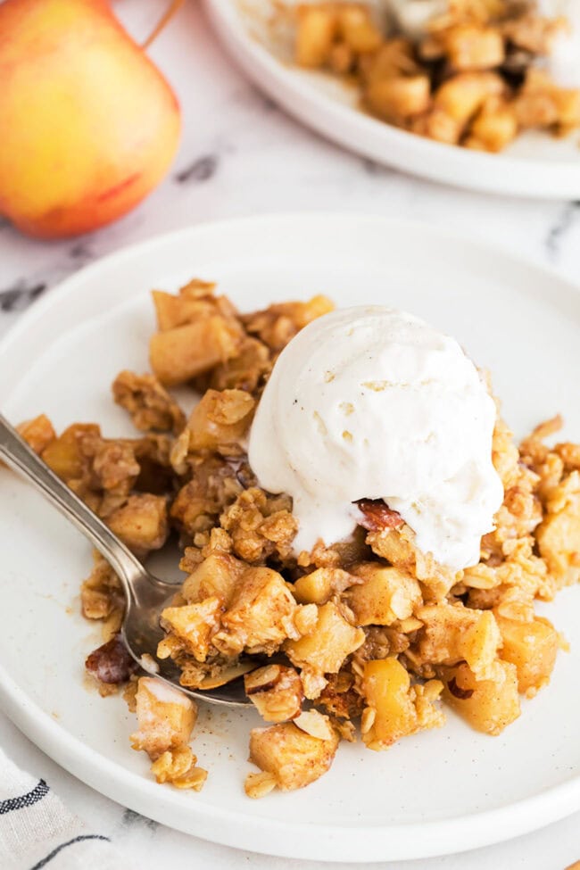 apple crumble on a place with a scoop of vanilla ice cream