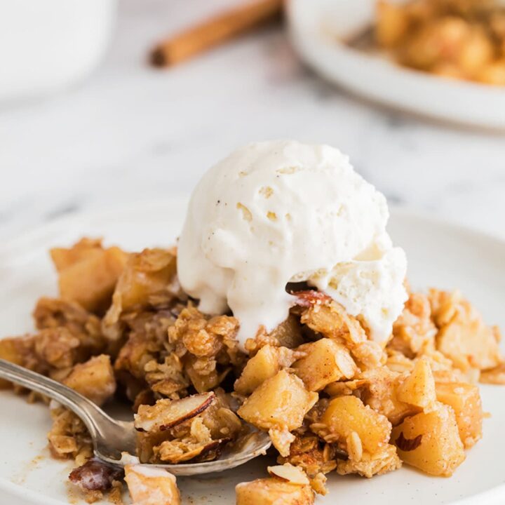 apple crumble on a plate with vanilla ice cream