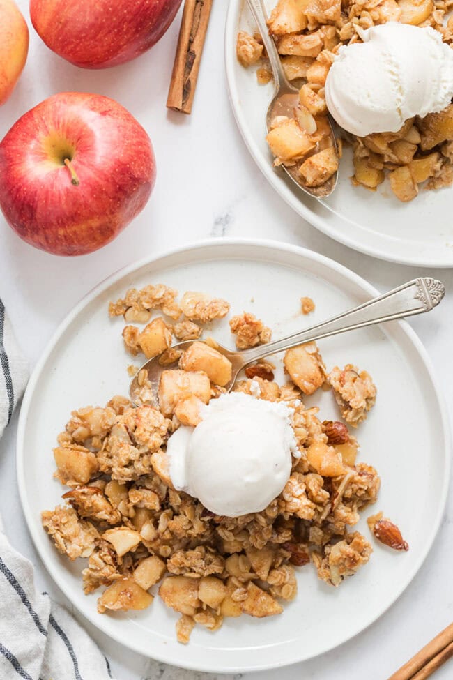 apple crumble on a plate with ice cream and a spoon