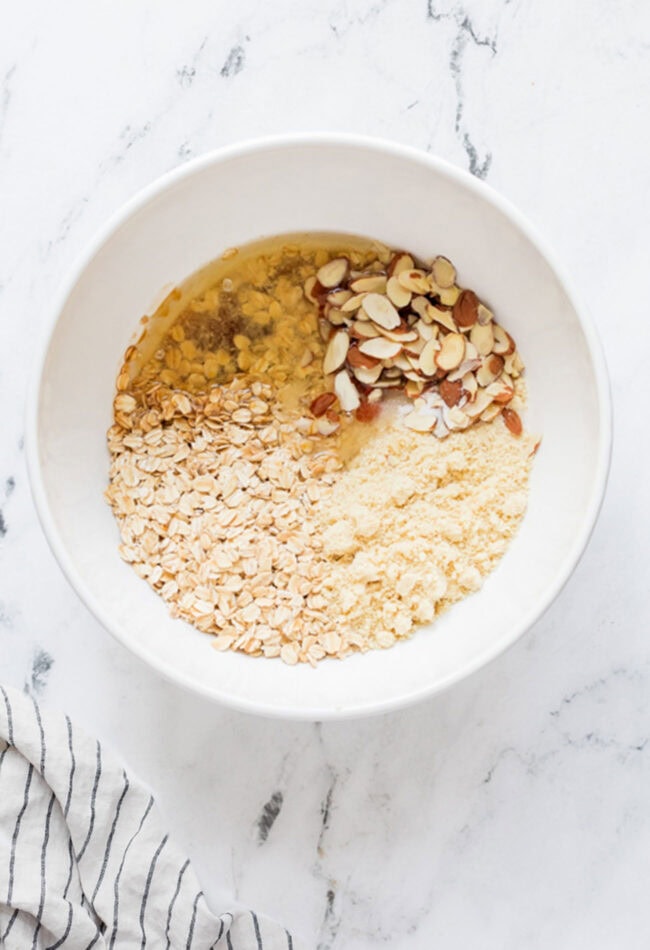 mixing crumble topping in a white bowl