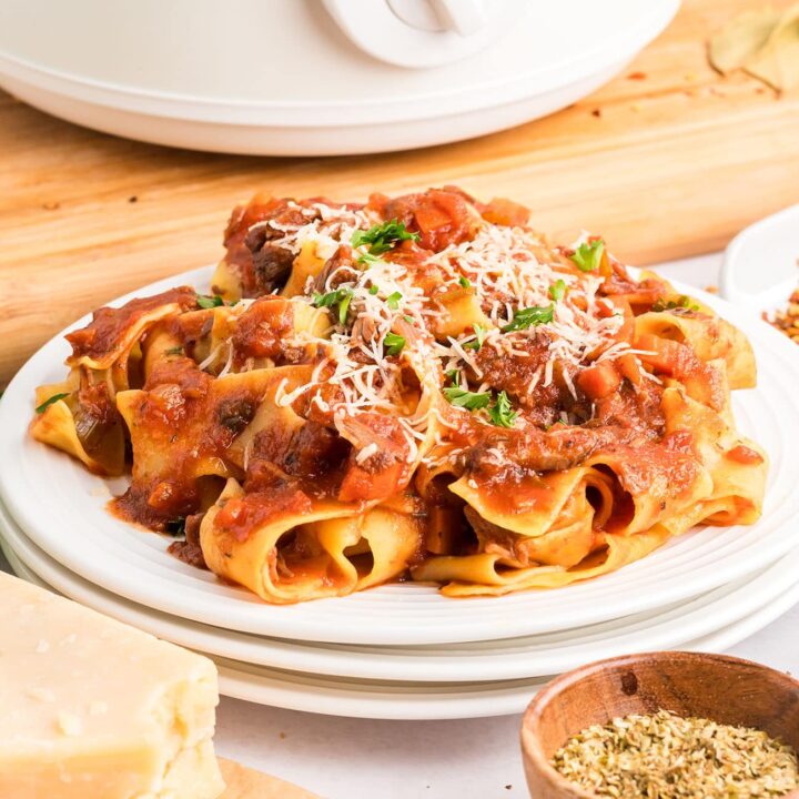 white plates with beef ragu and pasta