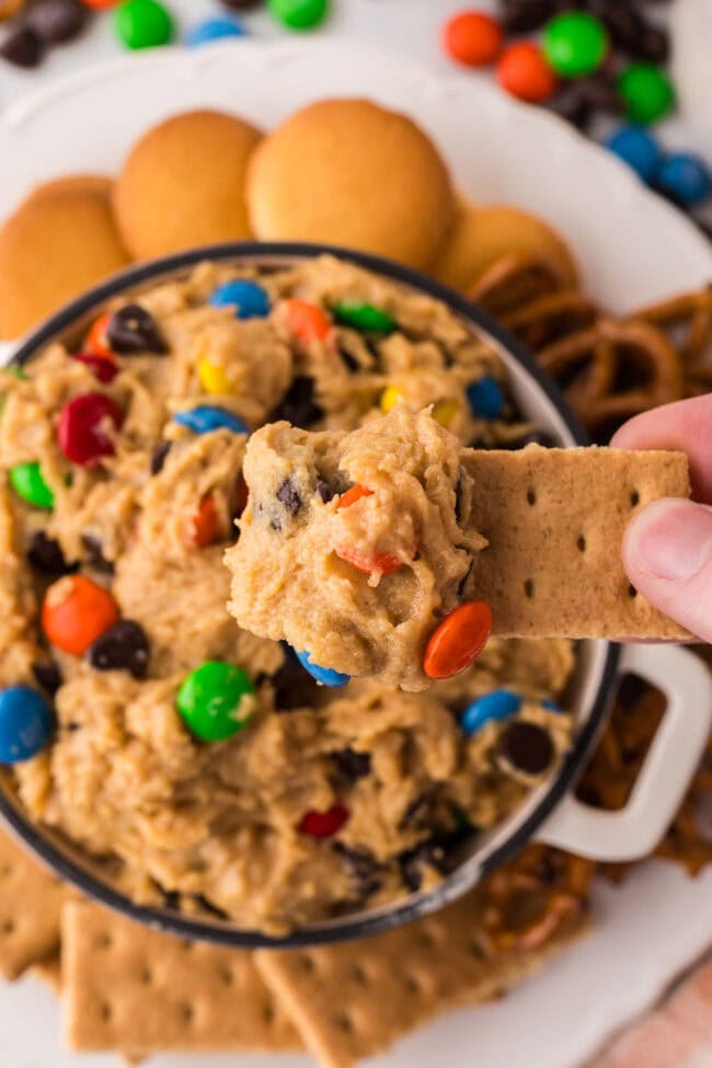 dipping a graham cracker in to a bowl of dessert dip