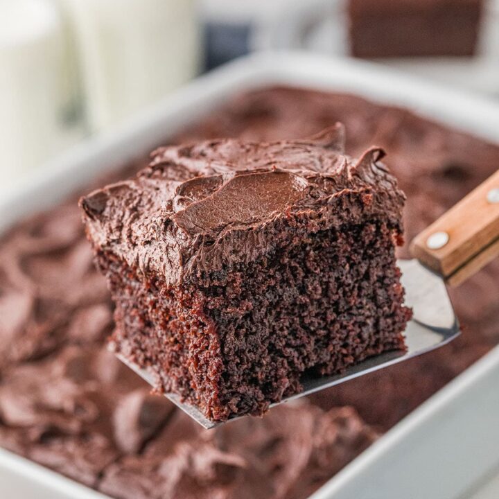 chocolate cake in a pan with a piece on a spatula