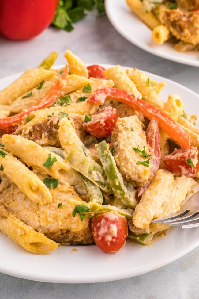 plate of pasta with fresh tomatoes and seasoned chicken