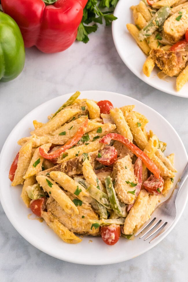 white plate and fork with cajun pasta with chicken