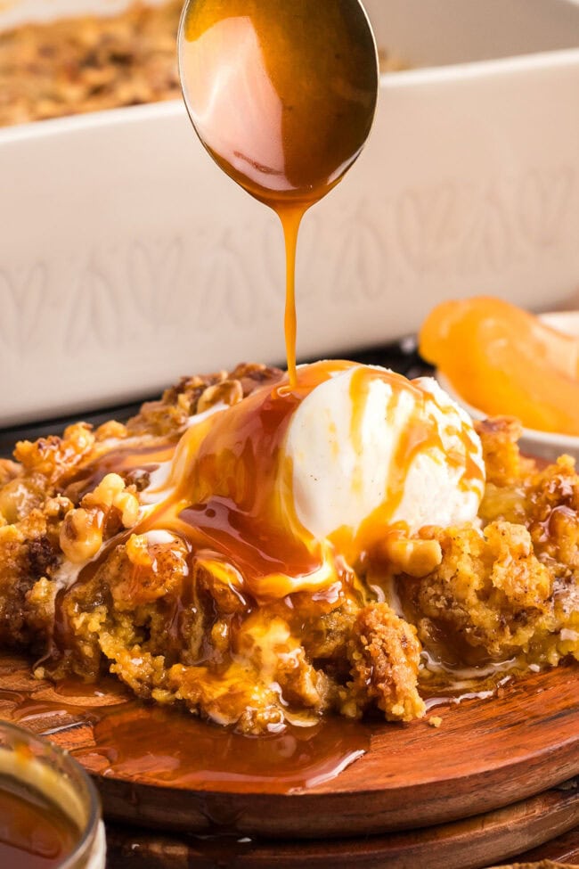 caramel apple dump cake drizzled with caramel sauce and a scoop of ice cream