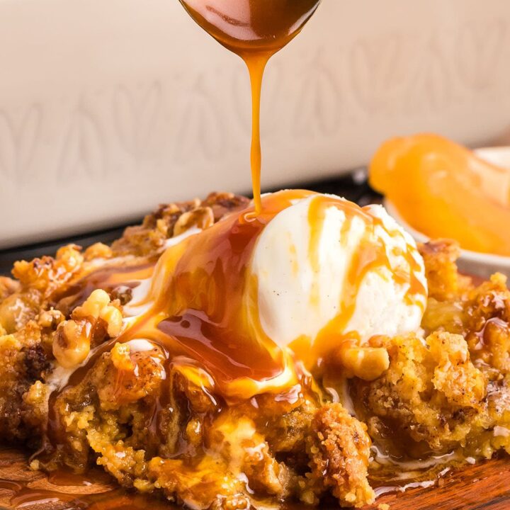 caramel apple dump cake drizzled with caramel sauce and a scoop of ice cream