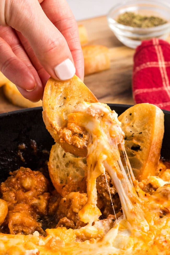 Lasagna Dip cheese pull on a toasted baguette