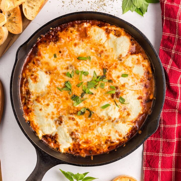 Lasagna Dip in cast iron skillet with a red towel