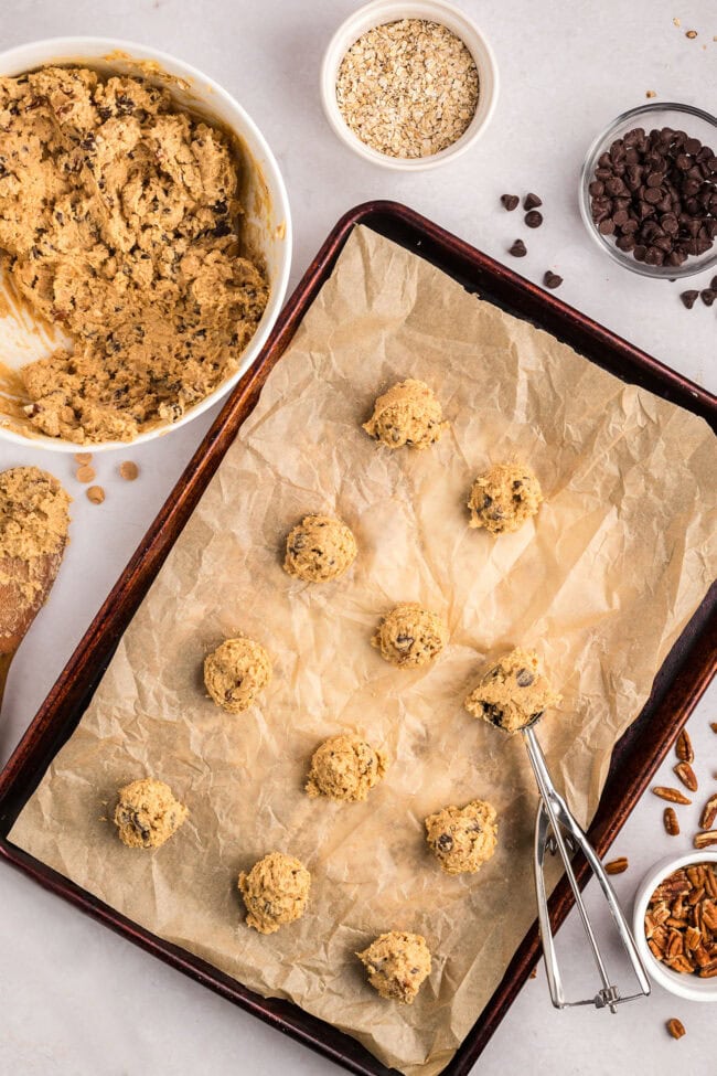 Peanut Butter Oatmeal Chocolate Chip Cookie dough balls on a baking sheet