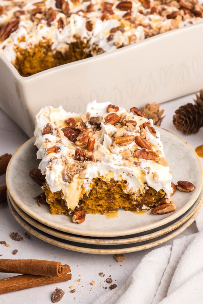 serving of Pumpkin Spice Poke Cake With Caramel Sauce on a stack of small plate