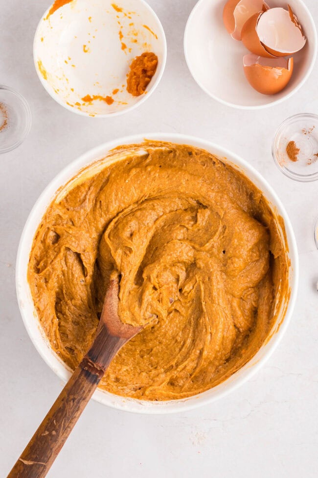 Pumpkin spice cake batter in a white mixing bowl