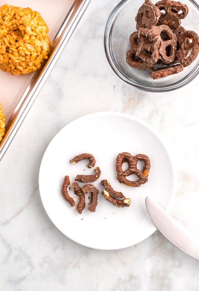 chopping up chocolate covered pretzels for Pumpkin Spice Rice Krispie Treats