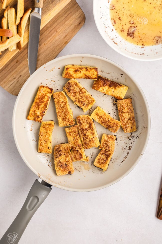 french toast sticks cooking in a skillet