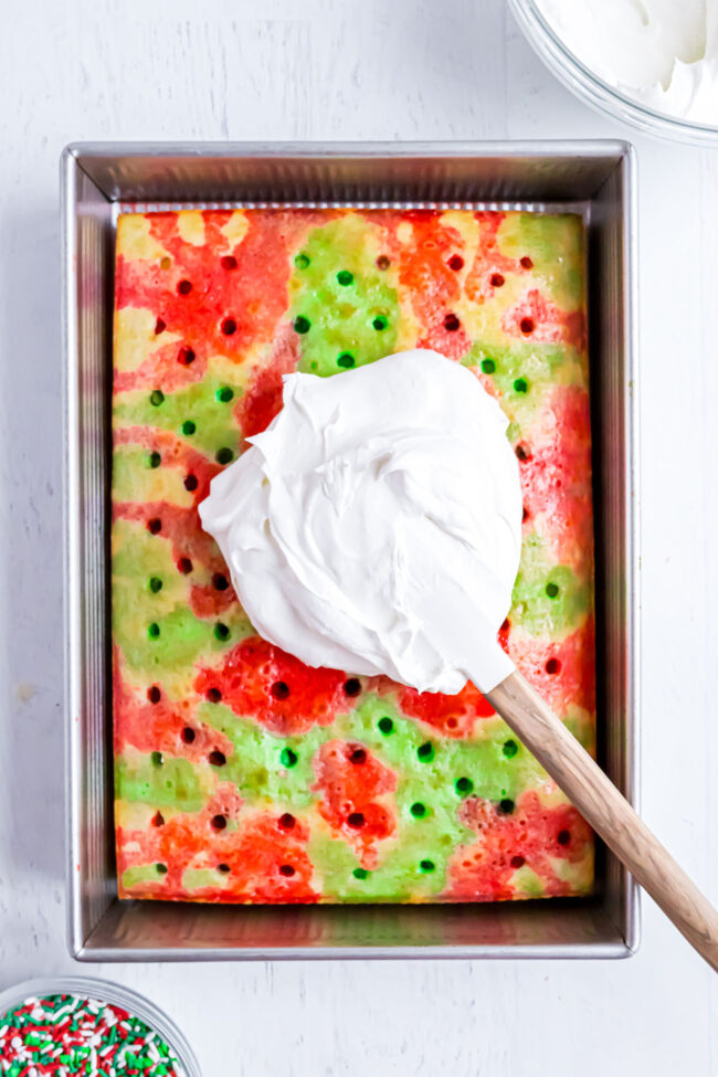 putting whipped topping on a Christmas poke cake