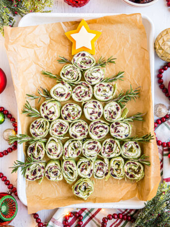 Christmas Tree pinwheel appetizers on a white pan with holiday decor