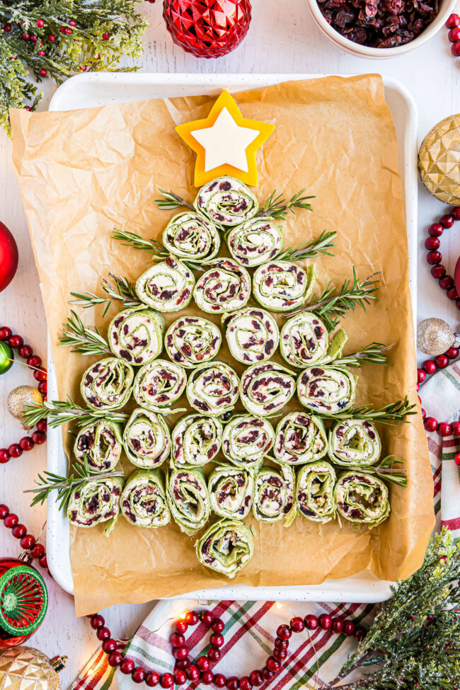 Christmas Tree pinwheel appetizers on a white pan with holiday decor