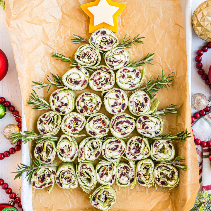 Christmas Tree pinwheel appetizers on a white pan with holiday decor