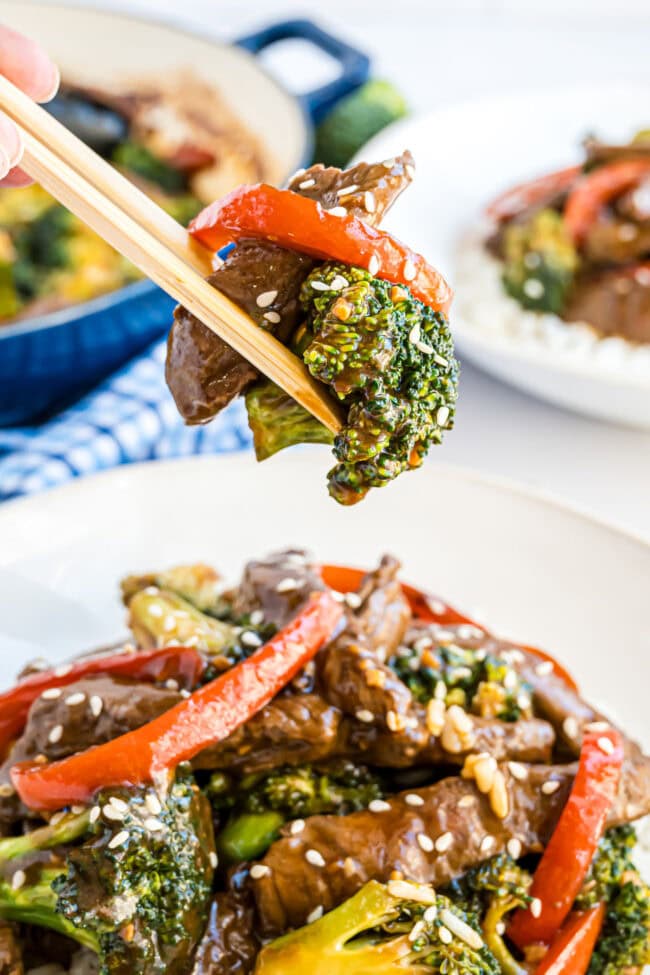 A bite of Beef and Broccoli with chop sticks