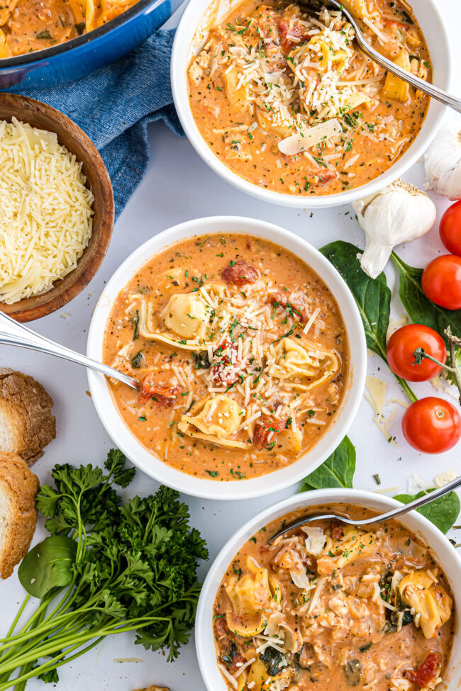 soup in bowls with spoons and fresh ingredients all around