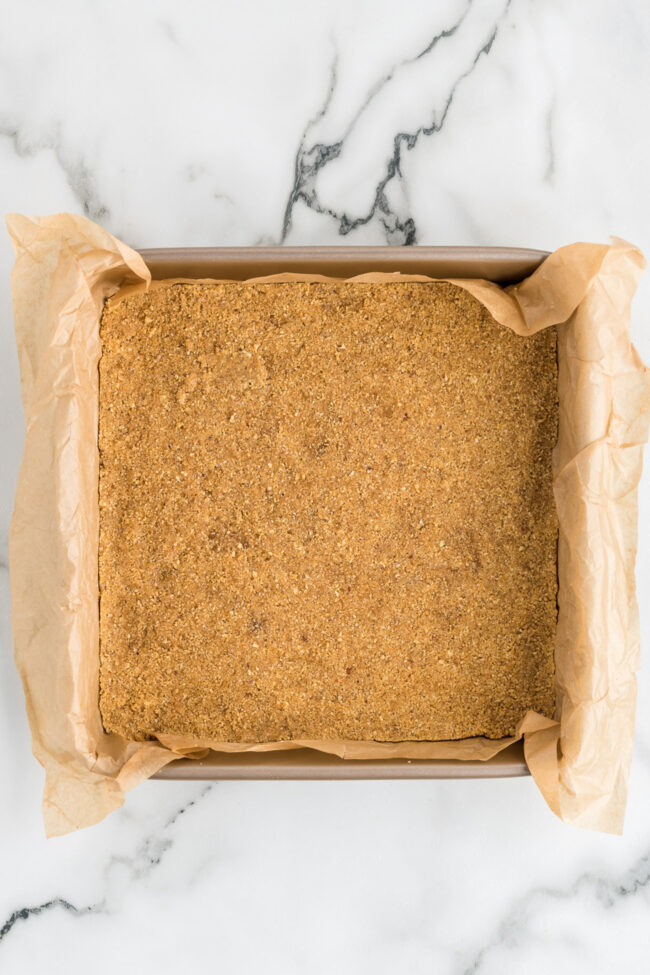 graham cracker crust in a square baking pan