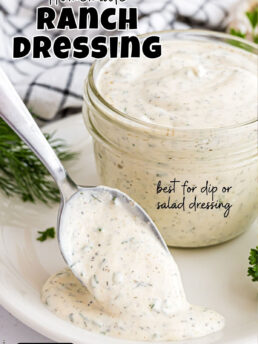 homemade ranch dressing in a jar with a spoon on the table