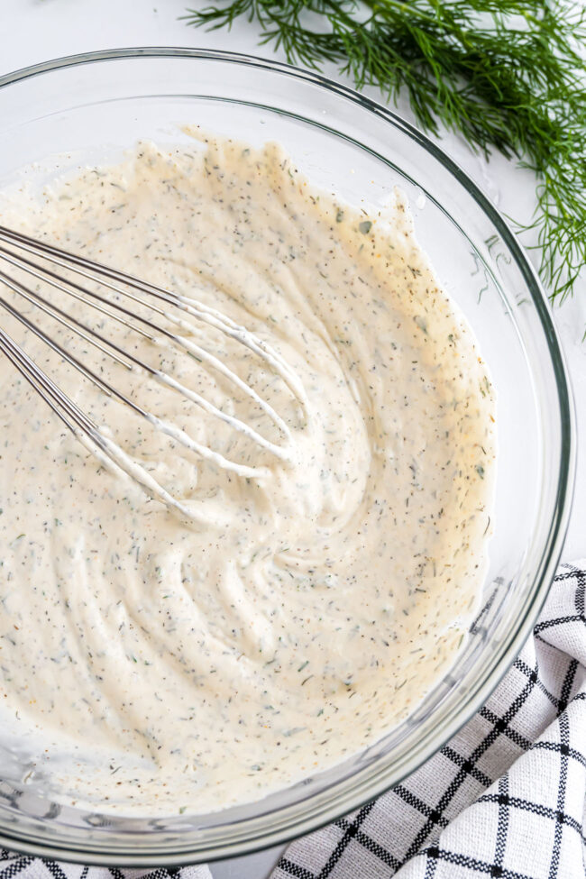 bowl of homemade ranch dressing and a whisk