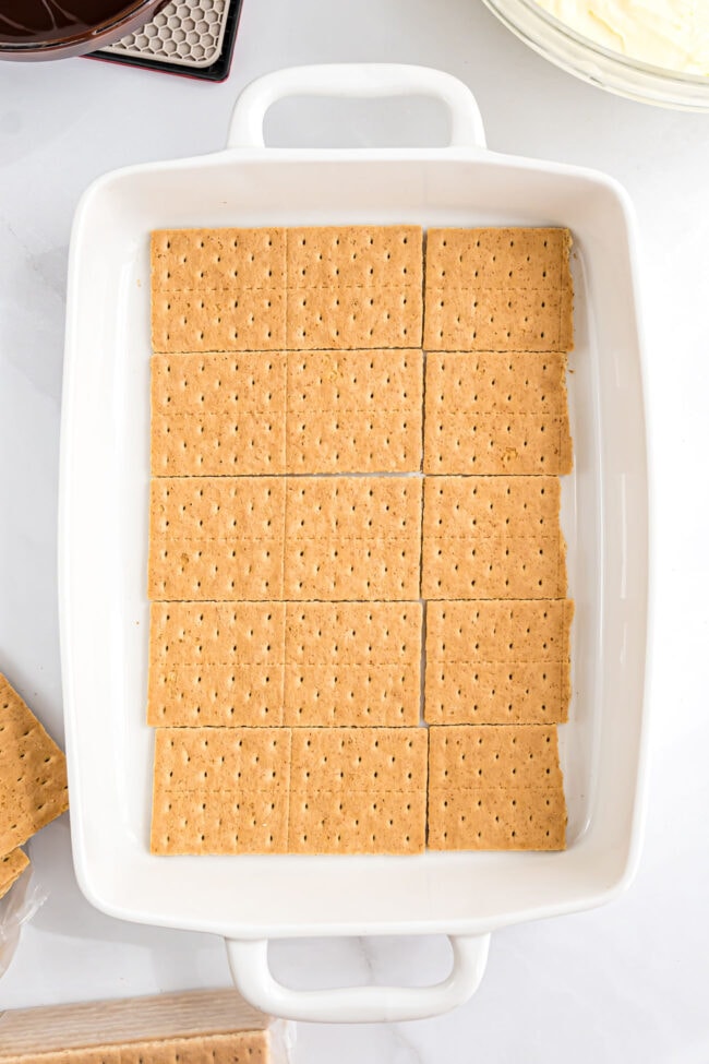 layer of graham crackers in a baking dish for a no bake eclair cake