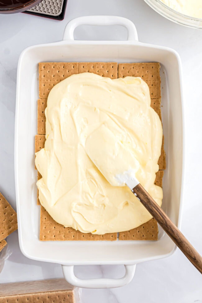 spreading pudding mixture over graham crackers for an ice box cake