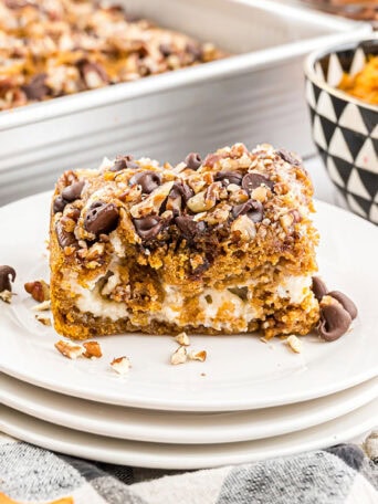 Pumpkin Earthquake Cake with pure pumpkin in a small bowl in the background and the baked dessert in a pan