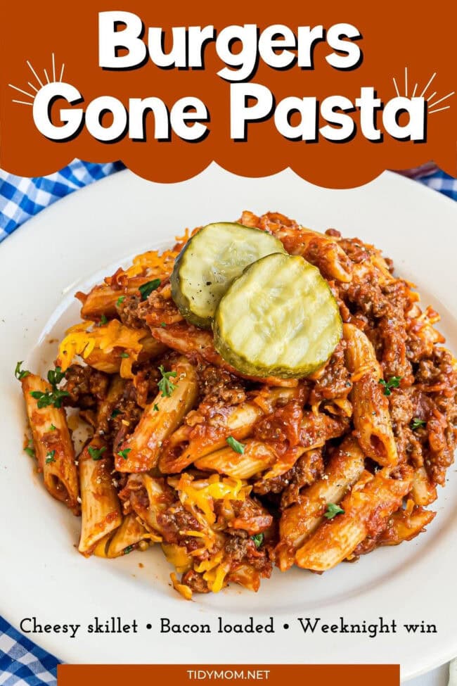Skillet of pasta mixed with ground beef, crispy bacon, and melted cheese, served with classic burger condiments on the side.