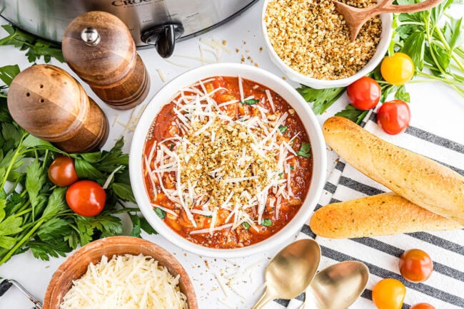 Slow cooker filled with Chicken Parmesan Soup ready to serve into a white bowl