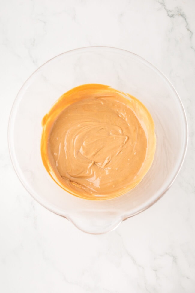 melted peanut butter and white chocolate chips in a bowl for a snack mix