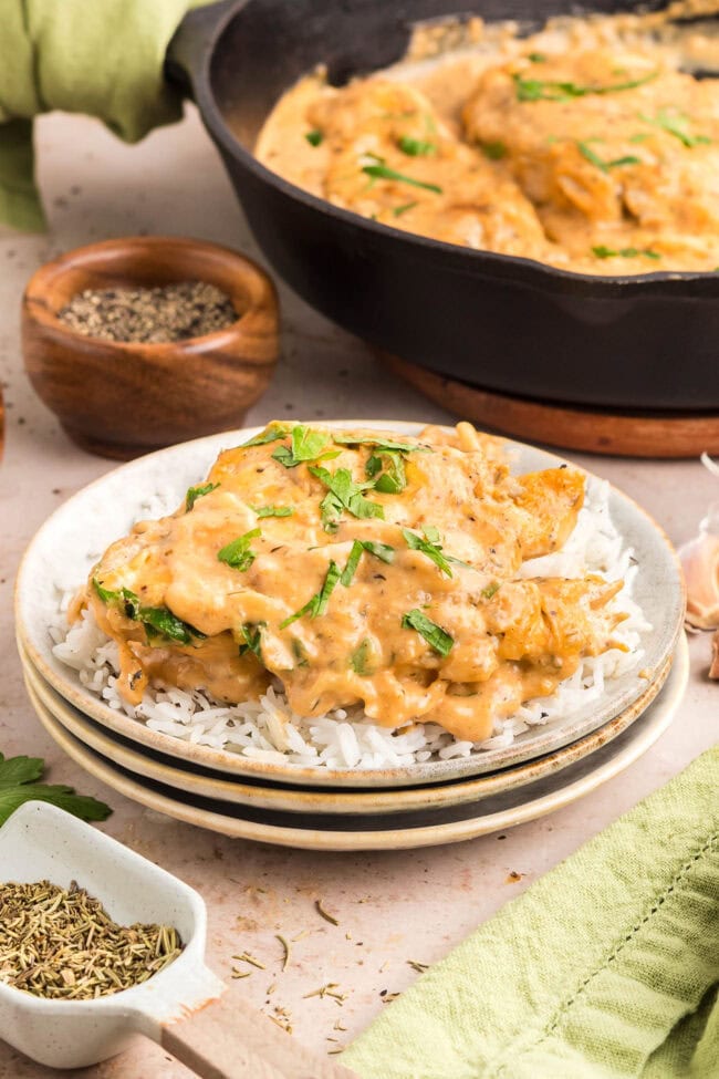 Creamy smothered chicken served on a plate with a rustic table setting.